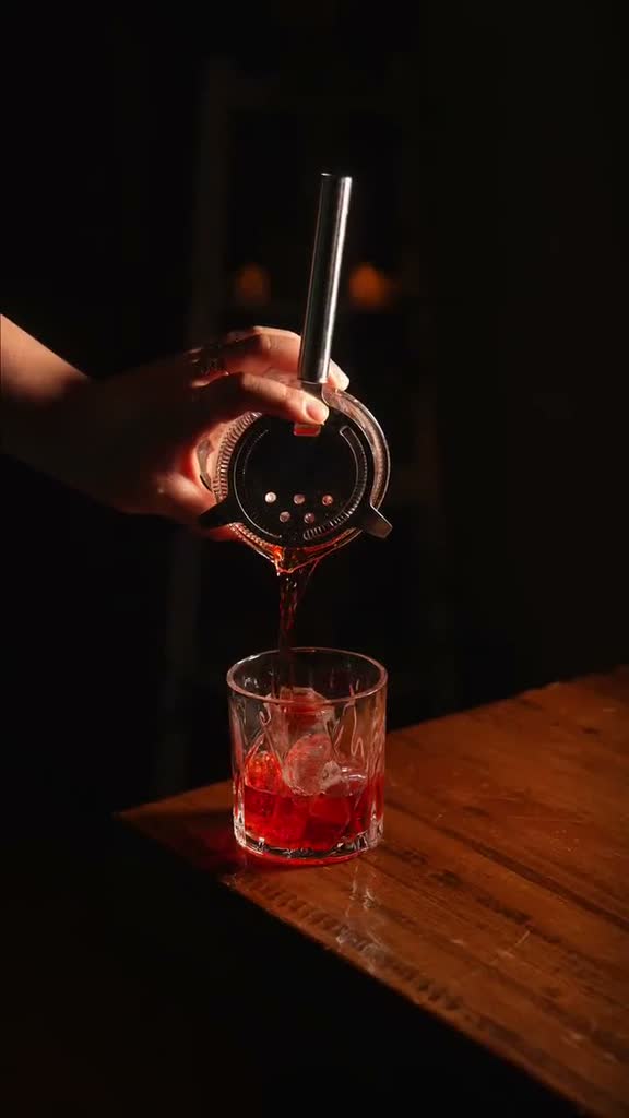 Un negroni recién colado sobre la barra, en penumbra.